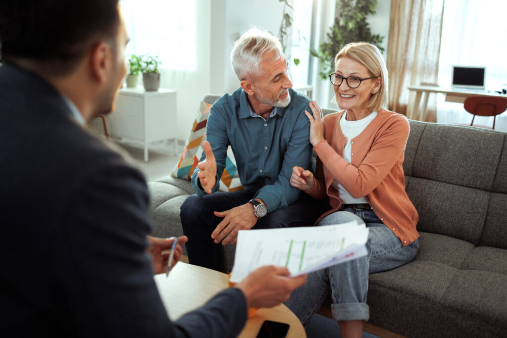 Immobilienberatung im Wohnzimmer mit zwei Kunden und Berater