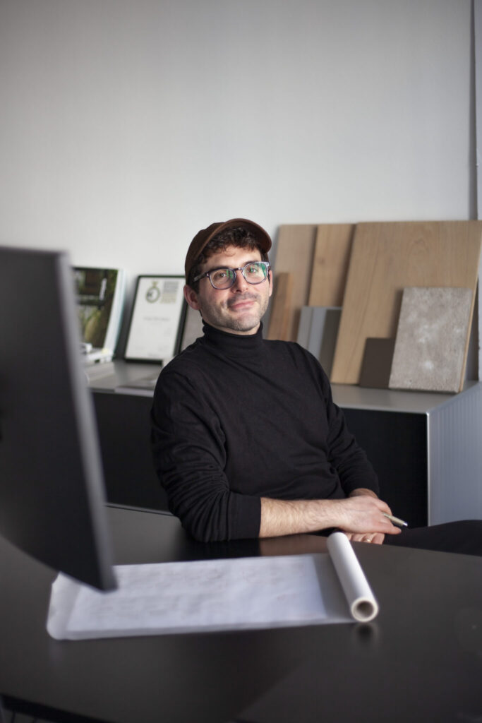 Architekt und Designer Emanuele ferraro im Büro mit Holz- und Oberflächenmustern im Hintergrund