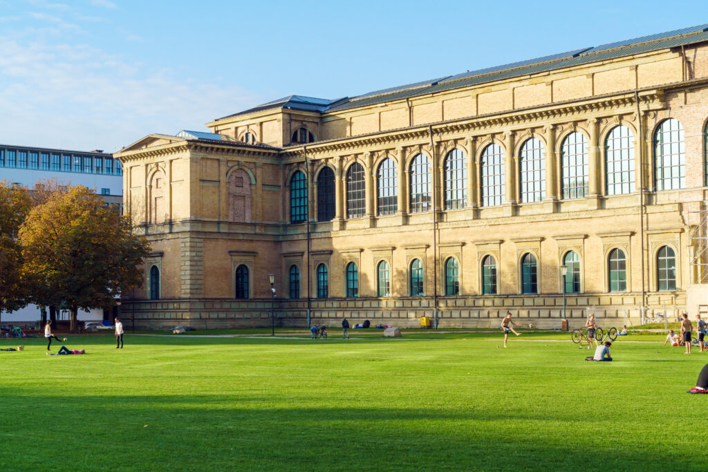 Menschen auf einer Rasenfläche vor Pinakothek in Maxvorstadt.